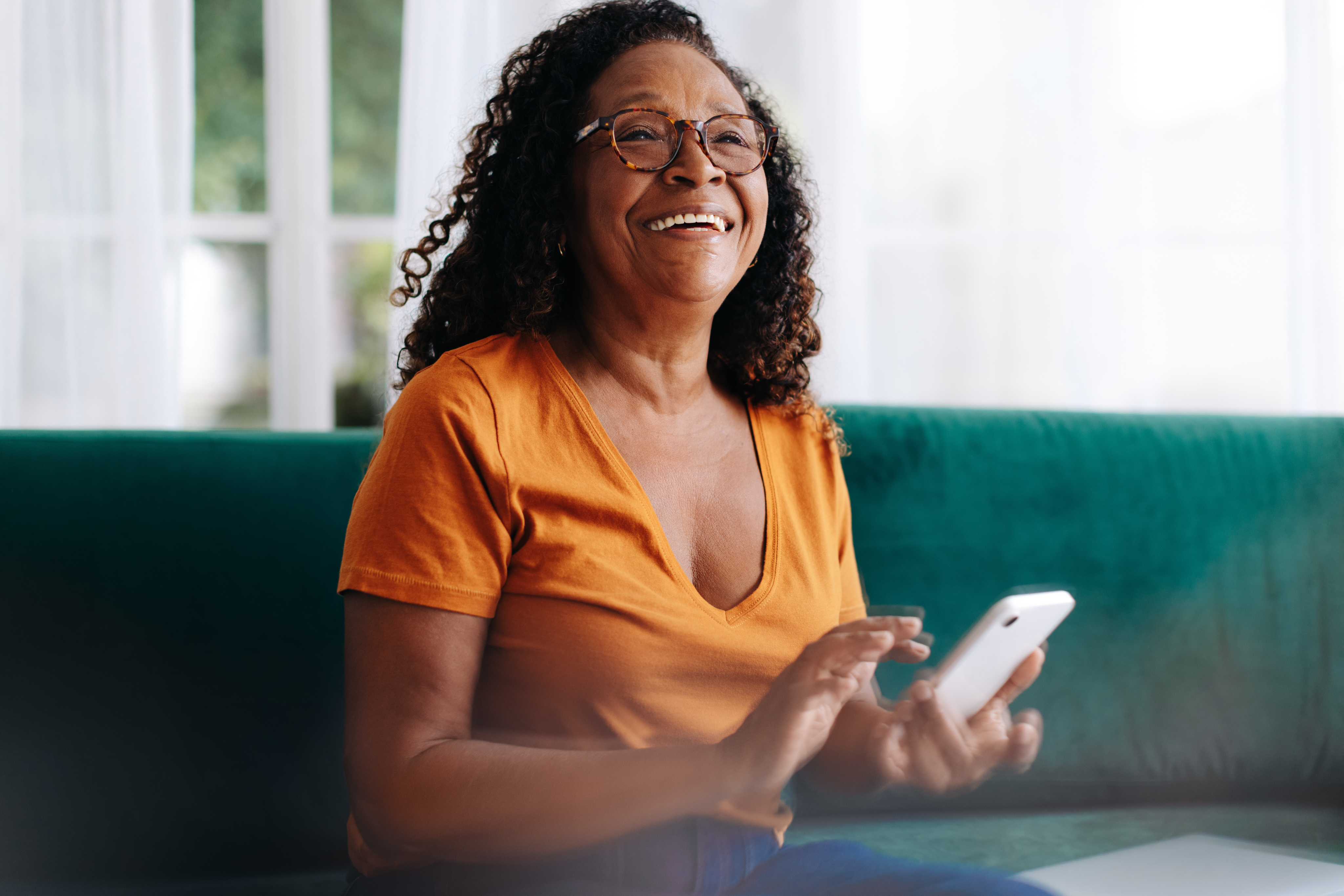 Une femme souriante utilise une tablette.