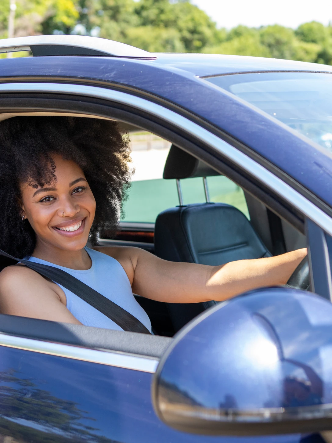 Une conductrice au volant de sa voiture.